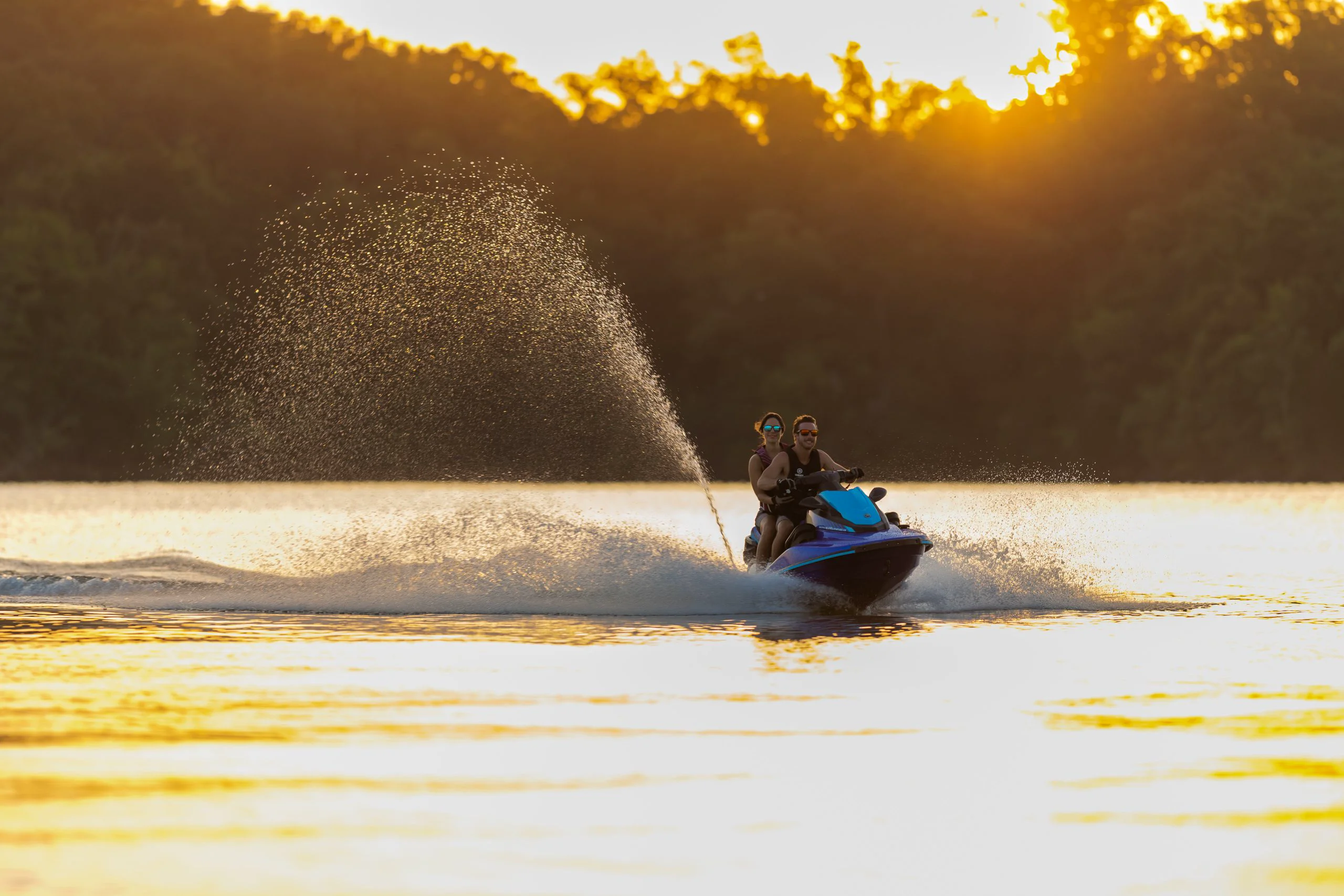 Casal pilotando jet ski ao pôr do sol no lago
