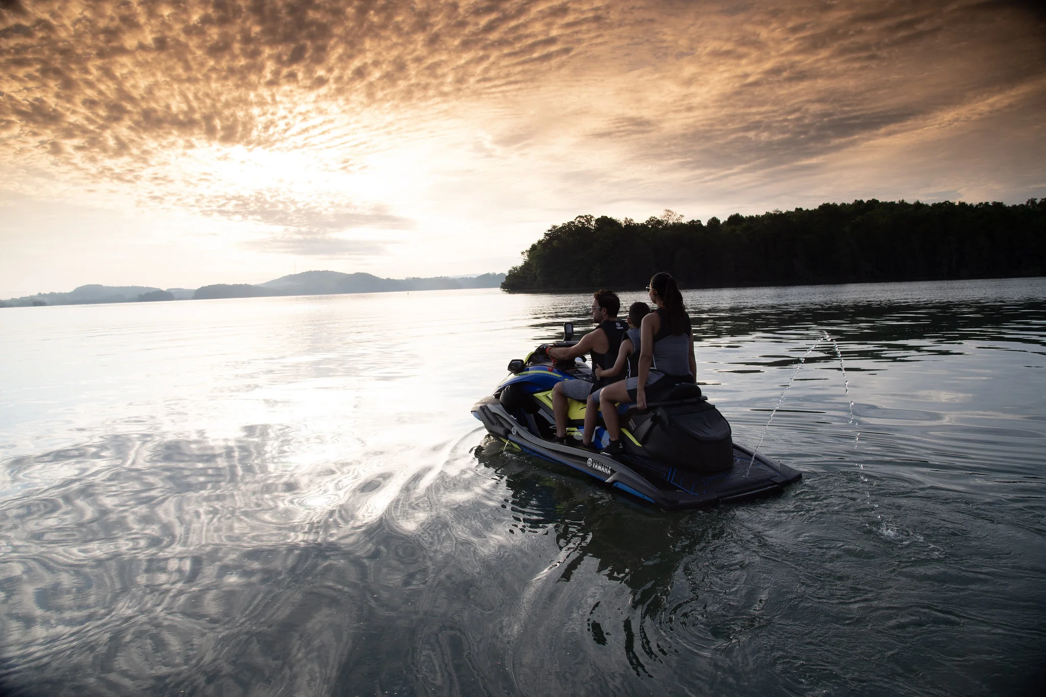 Família aproveitando jet ski ao pôr do sol no lago