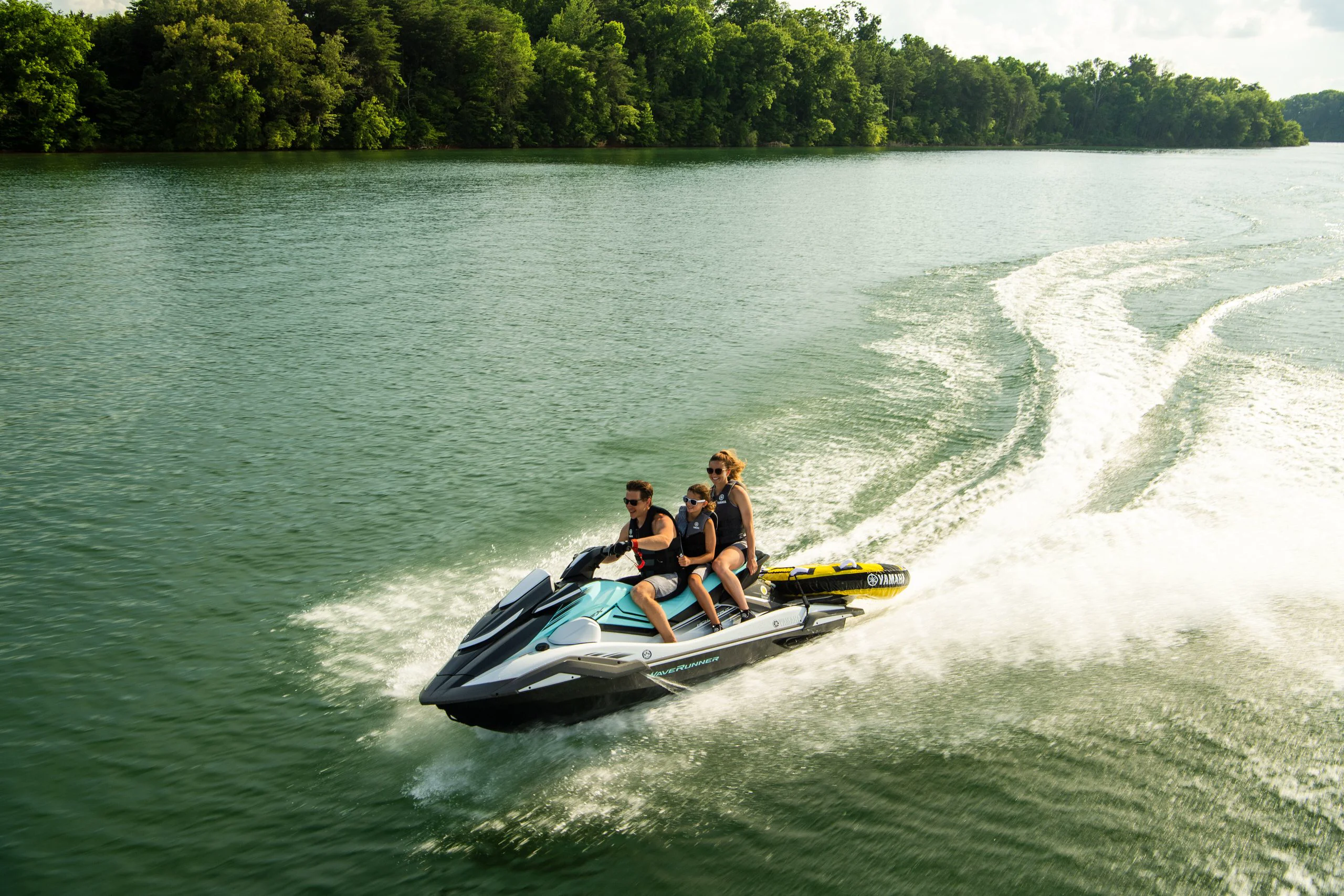 Família em Yamaha WaveRunner com boia no lago