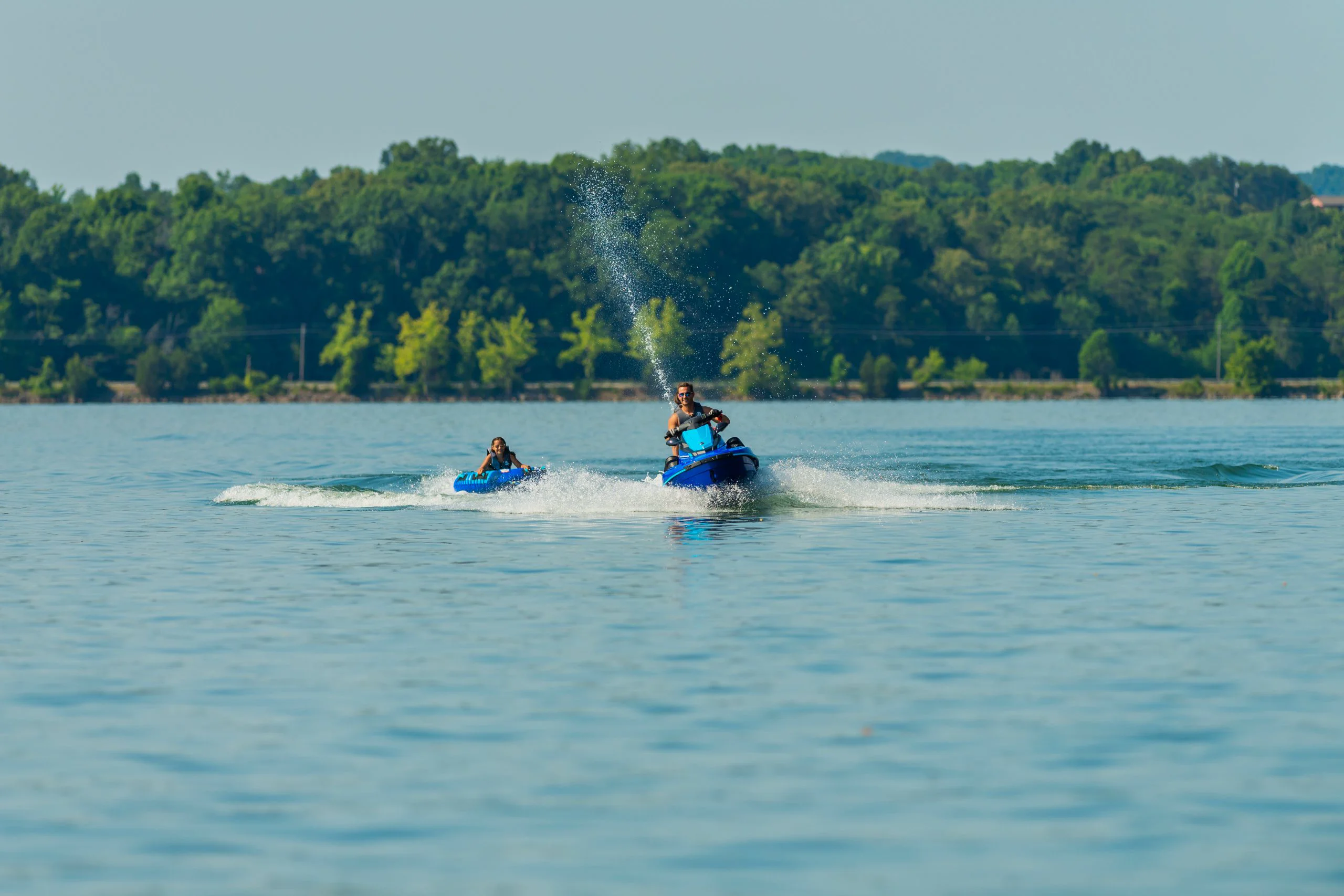 Jet ski rebocando boia com criança no lago